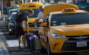 Yellow taxi cab picking up passenger at airport